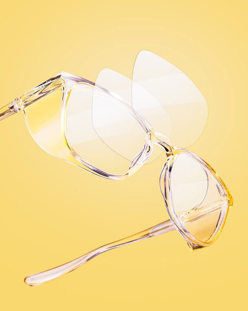Close-up of Stoggles protective glasses showing a layered 3D lens design on a bright yellow background.