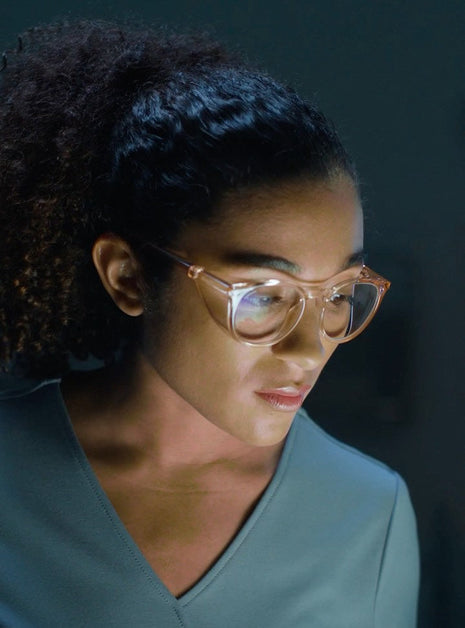  Woman wearing Stoggles Round Peach while working on a bright LED panel inside an operating room.