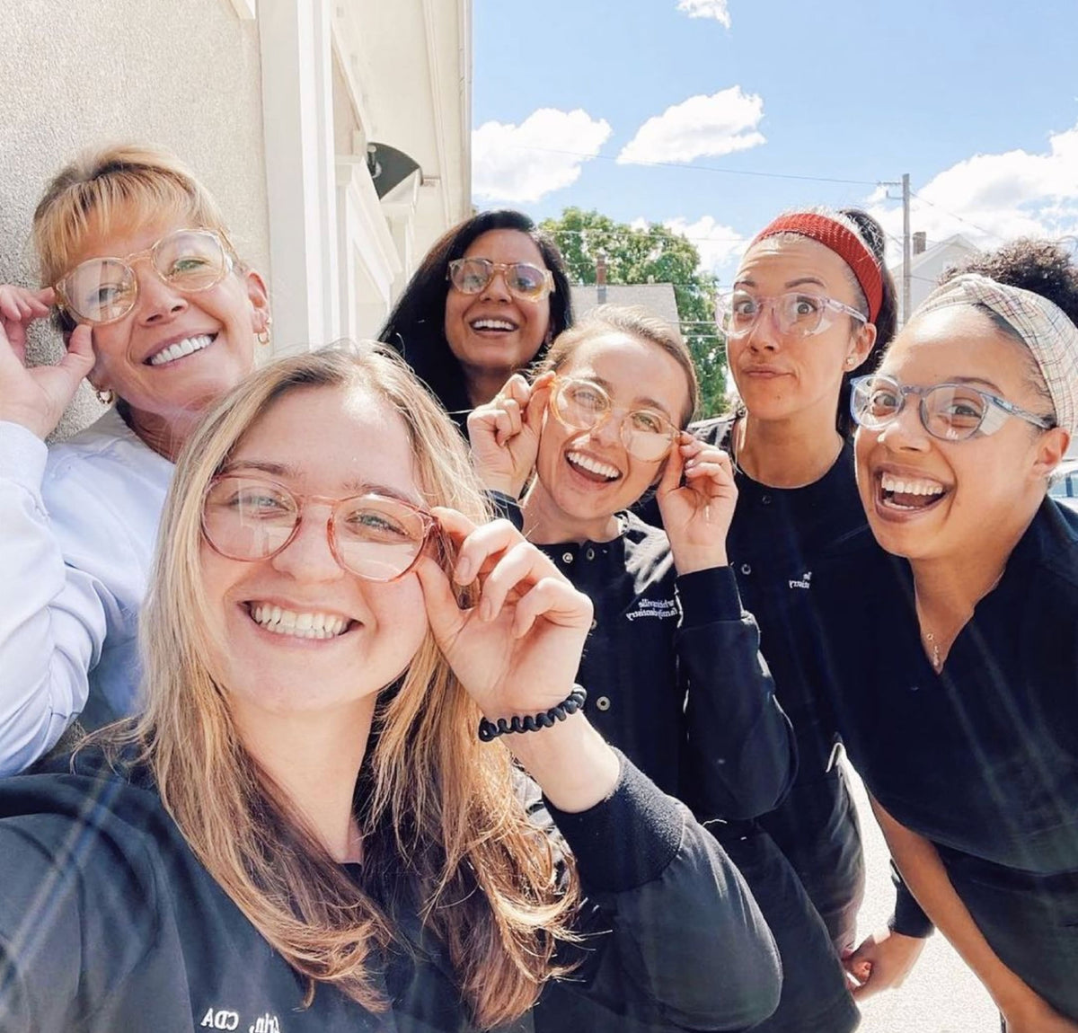 Team of dental assistants wearing Stoggles and smiling at camera